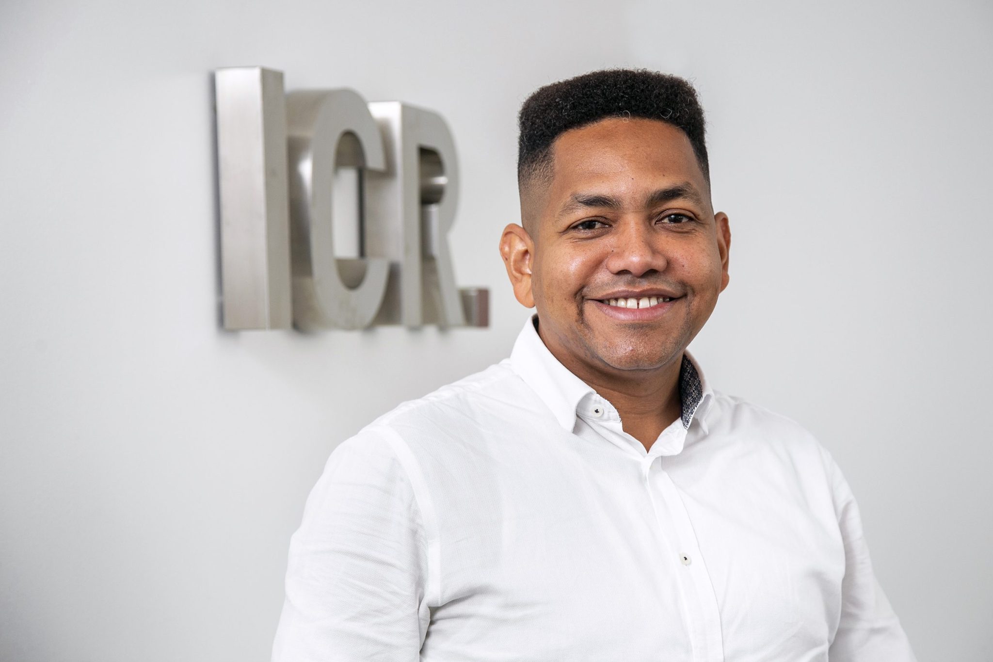 Antonio Caraballo wearing white shirt in front of ICR sign