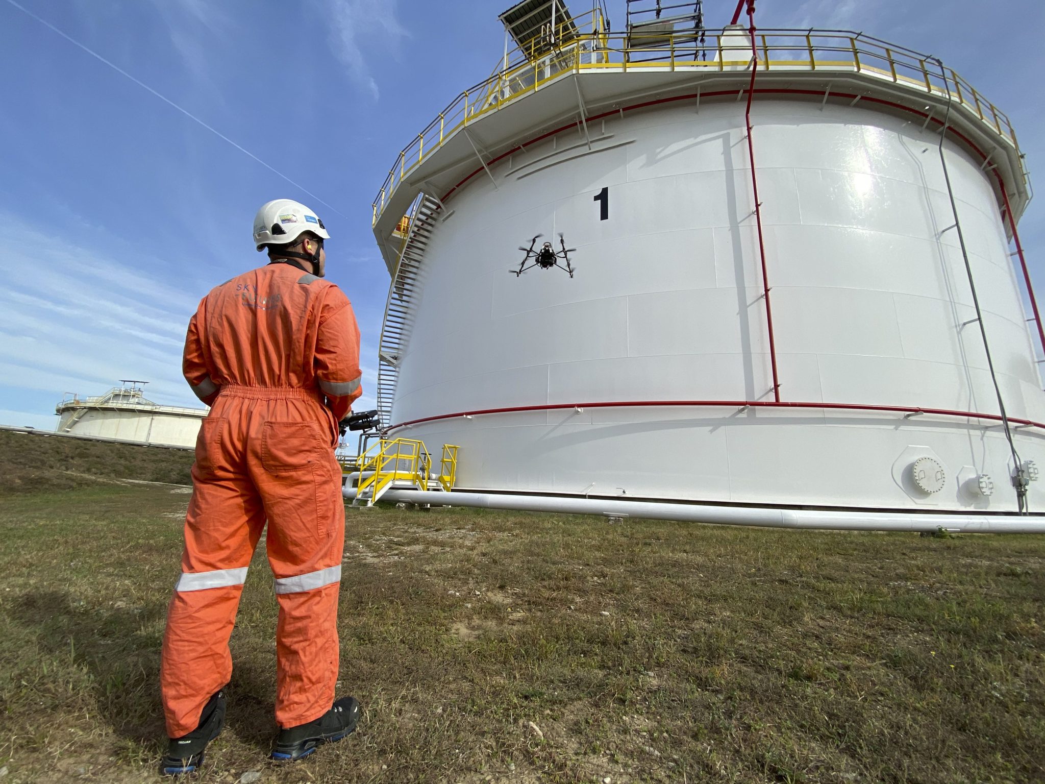 Drone pilot flying drone inspecting tank